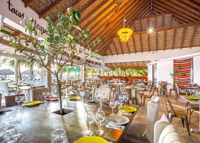 Bayahíbe Vida Nocturna

Para ser un pequeño pueblo costero, Bayahíbe tiene una vida nocturna vibrante, que va desde bares frente al mar al atardecer hasta una animada escena de baile los fines de semana. Este pueblo pesquero está tan vivo de noche como de día. Un puñado de bares en la playa son puntos de encuentro populares para disfrutar del happy hour con un cóctel al atardecer y seguir la fiesta hasta la madrugada. El colmado local, que también funciona como bar, comienza a llenarse desde las 6 p. m., con merengue y bachata resonando por el pueblo mientras la gente baila al aire libre. Además, las discotecas dentro de los hoteles en la playa Dominicus son otra opción popular para la diversión nocturna.