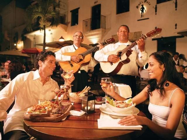 Santo Domingo Restaurantes

La cosmopolita ciudad de Santo Domingo está en constante reinvención. Cada mes, nuevos restaurantes abren sus puertas para satisfacer a los exigentes comensales locales. Comer fuera es una tradición en Santo Domingo, una ciudad que vive para socializar hasta altas horas de la madrugada (donde los lugares de desayuno son comunes), durante el almuerzo (no te pierdas los menús del día) y por la noche. La mayoría de los restaurantes se encuentran en el Polígono Central (áreas de Naco y Piantini), así como en las concurridas avenidas Gustavo Mejía Ricart y Winston Churchill, el Malecón, Chinatown o la Zona Colonial. Santo Domingo tiene más restaurantes que cualquier otra ciudad del Caribe o Centroamérica. Ofrecen especialidades dominicanas, caribeñas, latinas, mexicanas, del Medio Oriente, escandinavas, francesas, alemanas, italianas, españolas, chinas, coreanas y japonesas, muchas de ellas con un toque dominicano y, por supuesto, con ingredientes frescos locales. ¿Quieres probar la comida local? Todo se trata del sazón dominicano (sofrito), donde cilantro, orégano, ajo, cebolla, pimientos, tomates, alcaparras y aceitunas marcan la diferencia. Entre los restaurantes más populares para disfrutar de la comida dominicana en Santo Domingo se encuentran Adrian Tropical en el Malecón, Mesón de la Cava y El Higüero en el Parque Mirador del Sur, Cafetería El Conde y Mesón de Bari en la Zona Colonial, y Cane en la zona moderna de Santo Domingo.