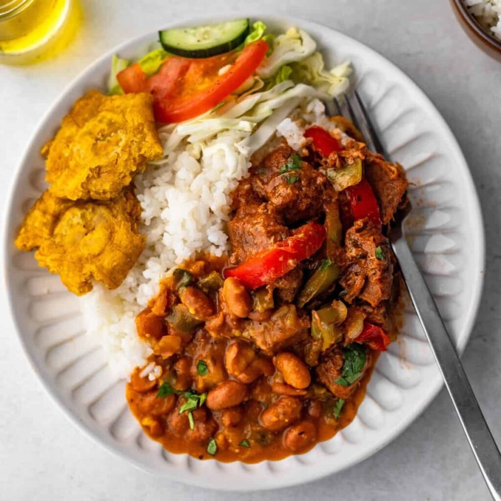 La gastronomía de República Dominicana destaca por platos criollos tradicionales como la Bandera Dominicana (arroz, habichuelas y carne) y el mangú con los tres golpes (plátano, huevos, queso, salami). Los restaurantes varían desde opciones locales económicas hasta experiencias culinarias, con un alto consumo de productos locales como plátano y arroz.  Lugares Destacados y Platos Típicos Desayunos Tradicionales: Se encuentran en restaurantes locales pequeños (llamados "comedores") o cafeterías. El plato estrella es el mangú con salami, queso frito y huevos, a menudo acompañado de jugo de chinola. Comida Casera ("La Bandera"): Es el plato nacional diario, indispensable en cualquier restaurante de comida criolla. Variedad: Se pueden encontrar lugares con opciones de alta cocina en zonas turísticas y restaurantes más sencillos y accesibles en las ciudades. Sabores Locales: Los yaniqueques y pastelitos son meriendas populares en puestos callejeros y restaurantes de playa.  Costos y Experiencia Presupuesto: La comida es asequible. Un gasto mensual razonable en alimentos puede rondar los USD 205 - USD 350, dependiendo del consumo de productos locales o importados. Experiencia: Se recomienda visitar "comedores" tradicionales para una experiencia auténtica y probar la auténtica cocina criolla dominicana.  